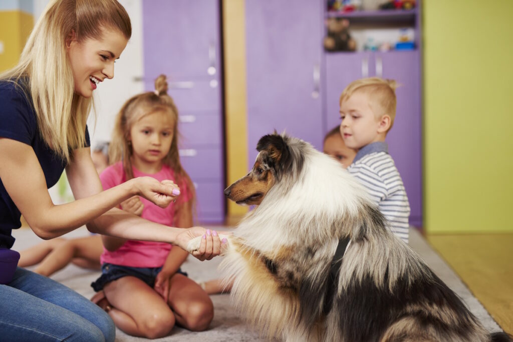 Teacher showing dog trick to children in classroom